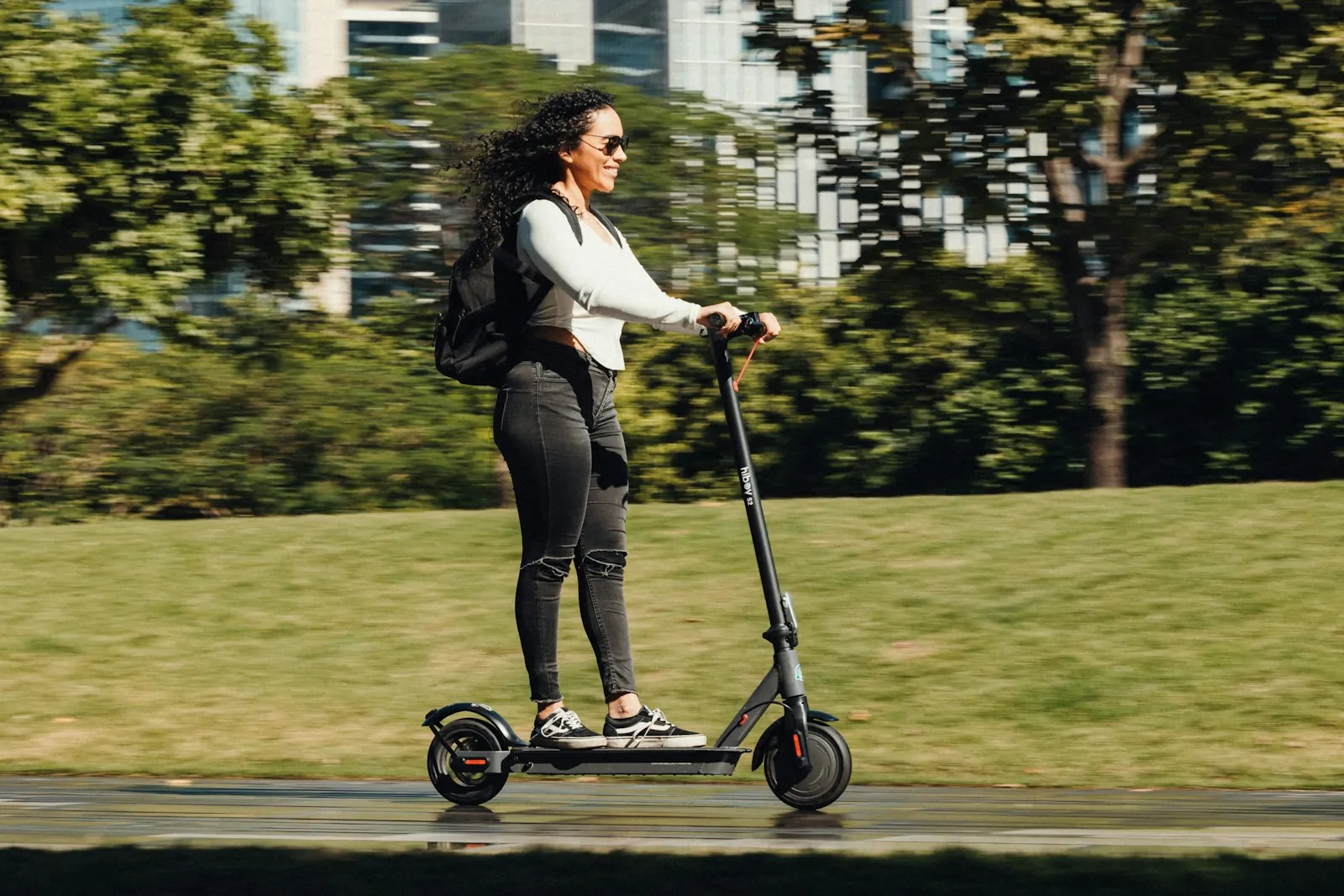 Una ragazza in monopattino elettrico nel parco